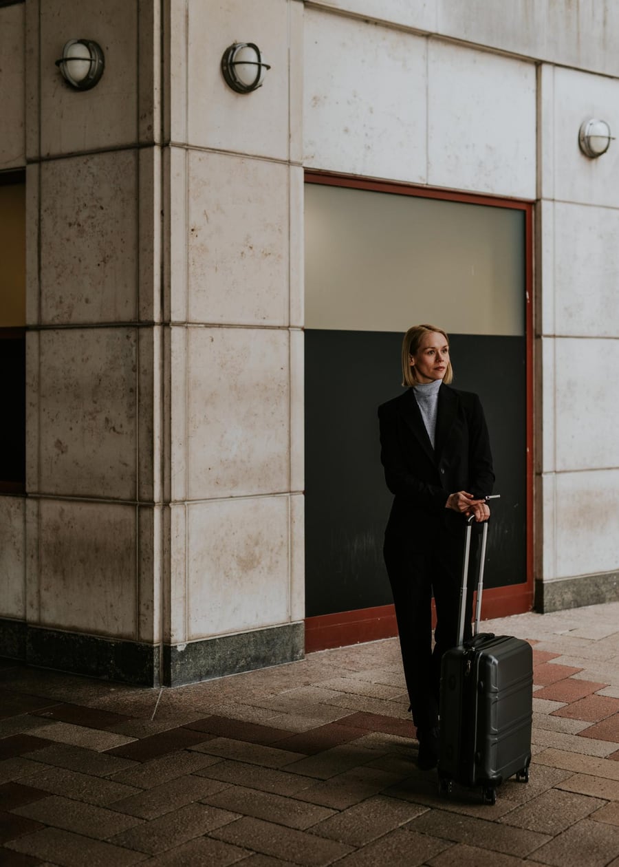 A business traveler with a rolling suitcase, ready for a corporate trip