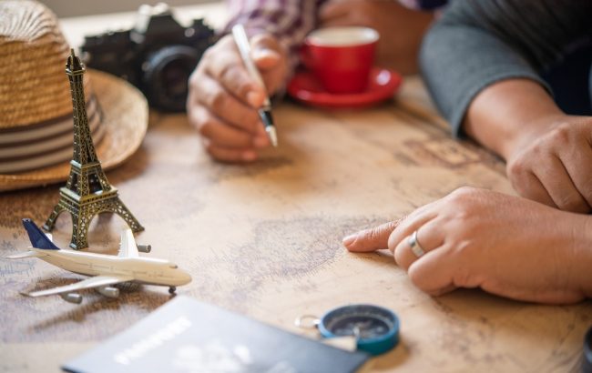 A traveler's flat-lay of a map, passport, and mini travel keepsakes, planning an itinerary over coffee